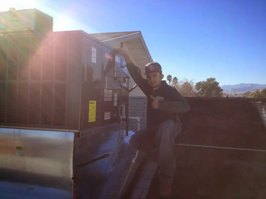 HVAC technician performing AC Tune-Up on a rooftop unit in Kennesaw